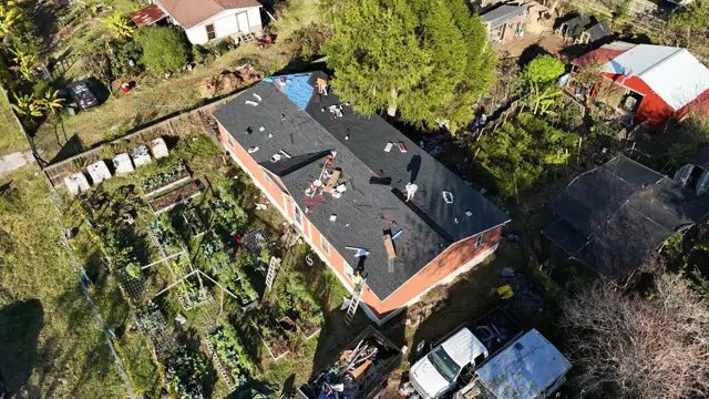 Shingles going on, seen from the drone: new dark asphalt shingles cover most of the Pearland roof as the crew finishes the final sections near one end. Overhead photos let Cloud IX check shingle lines, coverage and cleanup from above before the final walkthrough with the homeowner.