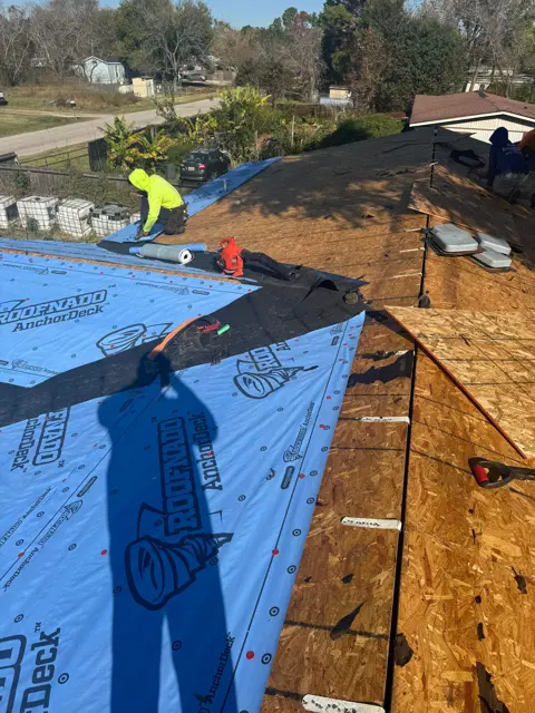 A Cloud IX crew member rolls synthetic underlayment over the new decking during the roof replacement. Underlayment is the secondary water barrier beneath the shingles, and it keeps the home dry during the build and protects it for the life of the roof if a shingle is ever damaged. The new decking and underlayment go down in the same day so the home is never left open to weather.