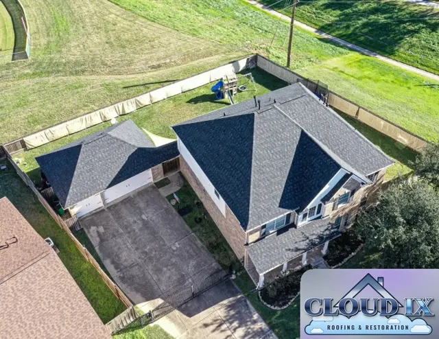 Finished charcoal shingle roof on a two-story brick home and detached garage in Tomball, TX